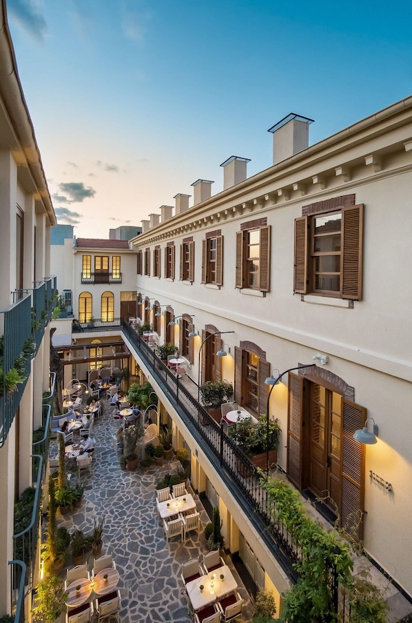 A courtyard with outdoor seating, a staircase, and a building facade with shutters and windows. - Ecole St Pierre Hotel (Istanbul)