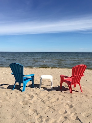 Three Adirondack chairs on a sandy beach with a view of the ocean. - New Listing! Lake Michigan Beachfront for All Seasons (Bark River)