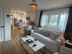 A modern kitchen with white cabinets, a central island, and a dining area.