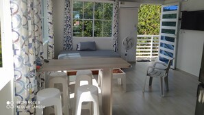A room with a bed, a table with chairs, a fan, and a TV. - Comfortable and safe apartment 3 minutes walk to the beaches (San Andrés y Providencia)
