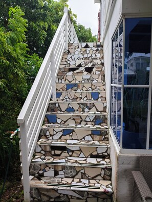 Una escalera con barandilla blanca y diseño de mosaico.