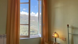A room with a window, curtains, a lamp, and a radiator. - Superba Vista by Interhome (Valloria)