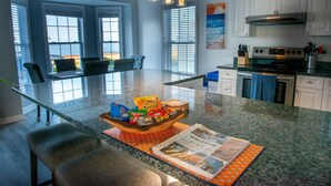 A kitchen with a central island, granite countertops, and a built-in oven. - Beachfront Getaway, Dolphin Suite, 🐶 💙 (Norfolk)