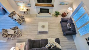 Ein geräumiges Wohnzimmer mit Kamin, Couchtisch und zwei Sofas.