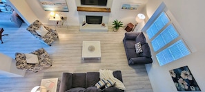 Un salon spacieux avec une cheminée, une table basse et deux canapés.
