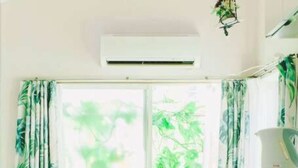 A room with a bed, a window with curtains, an air conditioning unit, and a microwave. - Home WIFI & Compact & Tranquil Apt with LOFT! (杉並区)