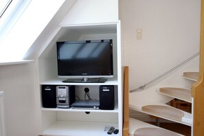 Um espaço compacto com televisão, sistema de som e arranhador para gato.