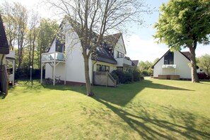 A residential property with a well-maintained lawn, a detached house, and a garage.