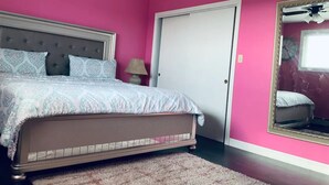 A bedroom with a bed, a nightstand, a lamp, a door, and a mirror. - Beautiful upper unit countryside large cozy rooms near Niagara Falls (Welland)