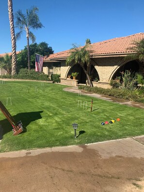 Enjoy a game of croquet on the well-manicured lawn, surrounded by a charming brick clubhouse.