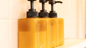 Three bottles of shampoo and conditioner on a shelf.