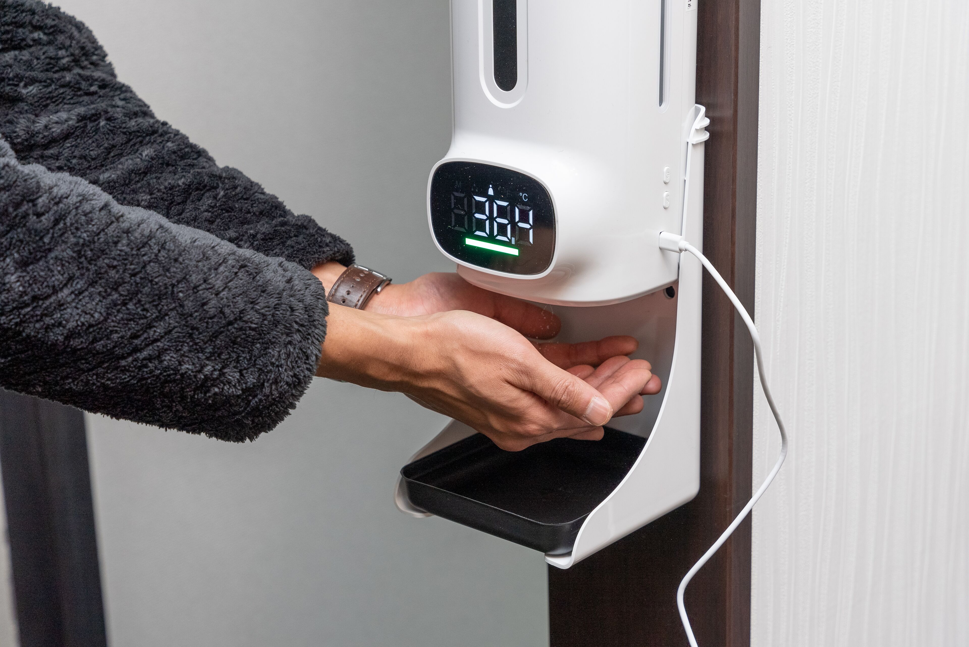 Une main dépose un smartphone sur une station de recharge.