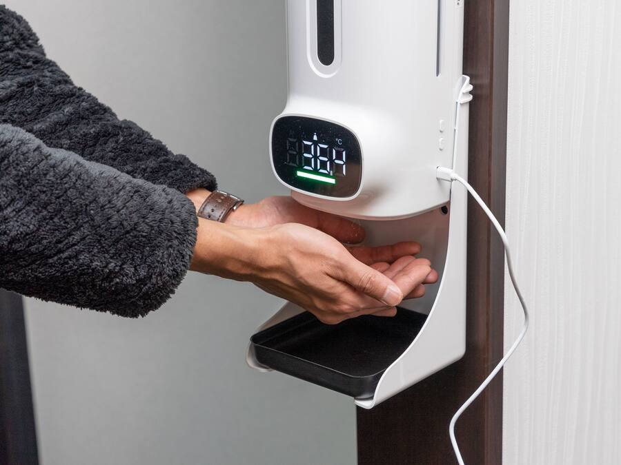 Une main dépose un smartphone sur une station de recharge.