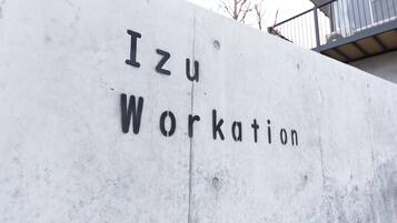 A concrete wall with the text "Izu Workation" engraved on it.
