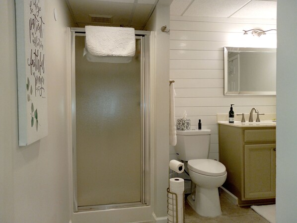 A bathroom with a shower, toilet, and sink.