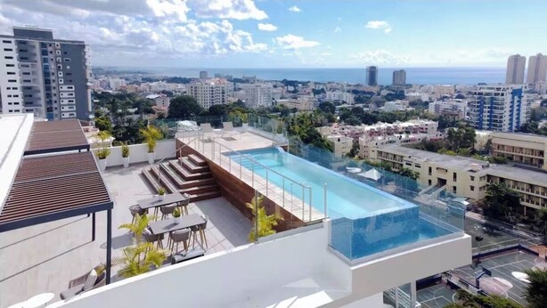 Una piscina sul tetto con vista sulla città e sull'oceano.