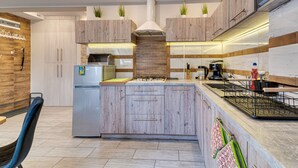 A modern kitchen with wooden cabinets, a central island, and built-in appliances. - Karpacz Boczna (poddasze) by Interhome (Karpacz)