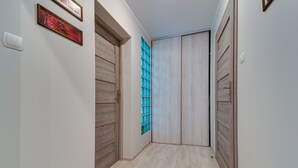 A hallway with wooden doors, a blue-tinted window, and a light-colored floor. - Karpacz Boczna (poddasze) by Interhome (Karpacz)