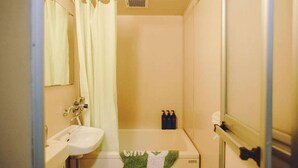 A small bathroom with a sink, a toilet, a shower curtain, and a mirror. There are toiletries on the wall and a towel on the floor. - Home WIFI & Compact & Tranquil Apt with LOFT! (杉並区)