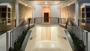A grand staircase with a handrail, leading to an entrance with a wooden door. - Discovery Guest House -Sur (Sur)