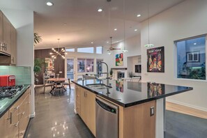 A modern kitchen with a central island, built-in appliances, and ample natural light. - Luxe Mid-Century Home w/ Mtn & Golf Course Views (Palm Springs)