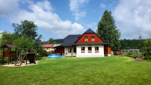 A house with a red roof, a swimming pool, and a playground. - Newly built cottage with pool and  large fenced garden (Ždár nad Sázavou)