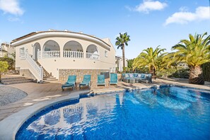 A resort with a swimming pool, lounge chairs, and a palm tree. - Villa with Private Pool, Garden, Air Conditioning & Wi-Fi (Ciudad Quesada, Rojales)