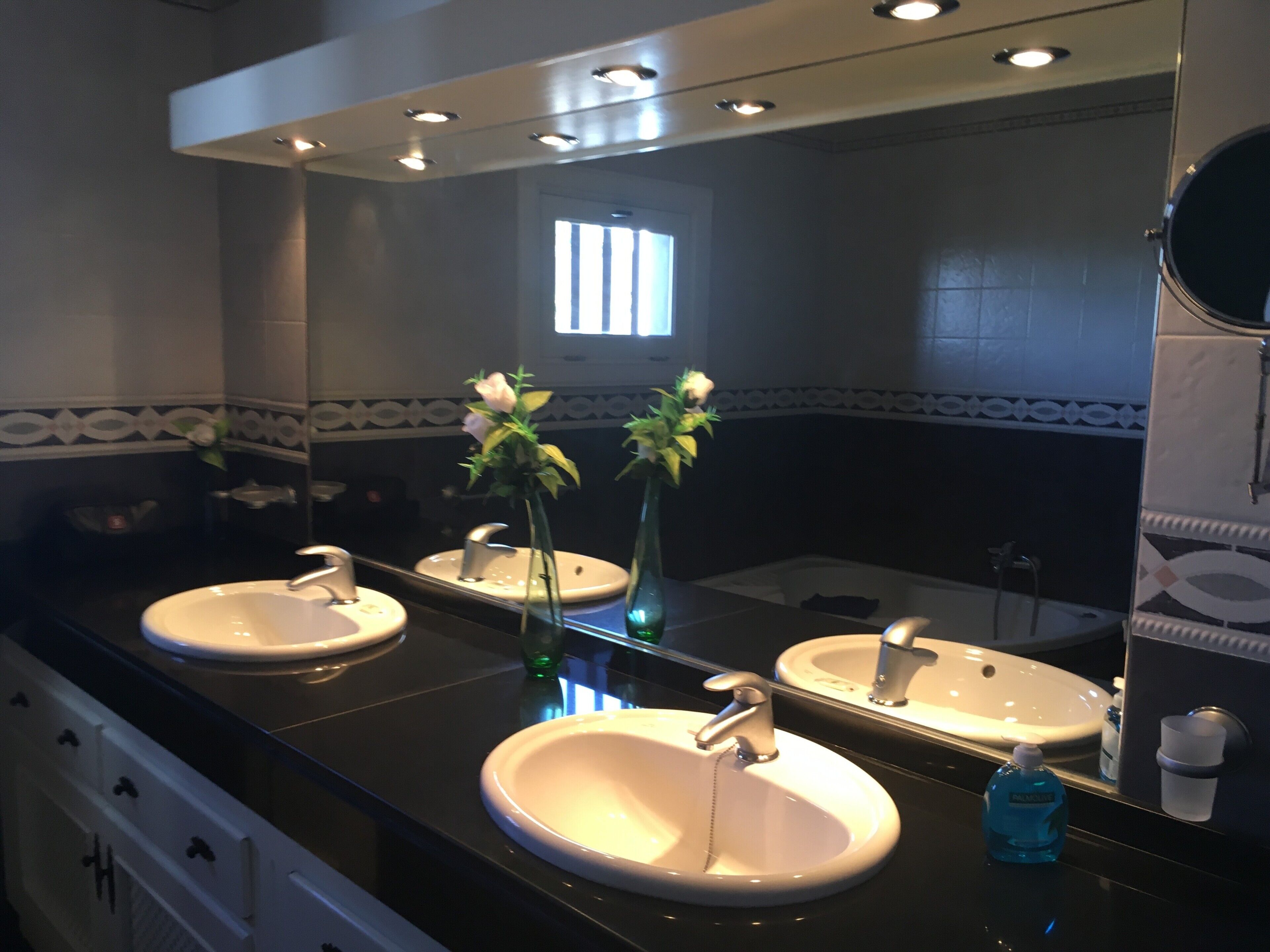 A bathroom with two sinks, a mirror, and a window.