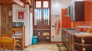 A compact kitchen with wooden cabinets, a microwave, a sink, and a window with a view. - Holiday Home with Mountain Views, Balcony and Wi-Fi (Los Valles)