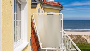 Ein Balkon mit Blick auf Strand und Meer.