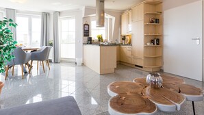 Eine moderne Küche mit einer zentralen Kochinsel, Holzschränken und einem Essbereich mit Tisch und Stühlen.