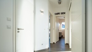 En hall med en dörr som har texten ”CARPE DIEM” på sig, och som leder in till ett badrum.