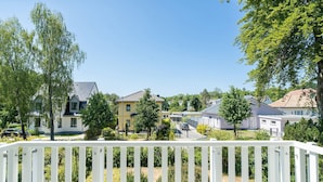 Ett bostadsområde med hus, ett vitt staket och grönområden.