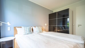 A modern bedroom with a large bed, a bedside table, a mirror, and a wardrobe. - Seeresidenz Haus Atlantic, App. C02 (Heringsdorf)