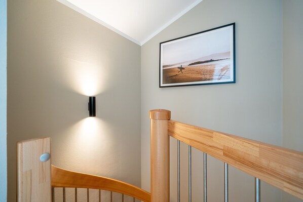 A staircase with wooden railings and a wall-mounted light fixture.