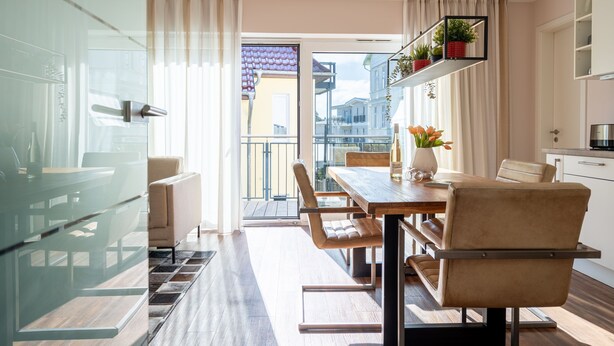 A modern kitchen with a dining area, a view through the glass door, and a balcony. - Quartier Ahlbeck, app. 04 (Heringsdorf)