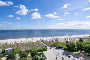 A beachside promenade with a clear view of the sea, a sandy beach, and a pathway leading to beachside facilities. - Beachhouse Bansin, Penthouse Waterfront (Heringsdorf)