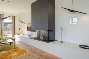 Un salon moderne avec une cheminée, une table basse en verre et un canapé.