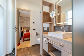Une salle de bain moderne avec un grand miroir, un lavabo et des toilettes.