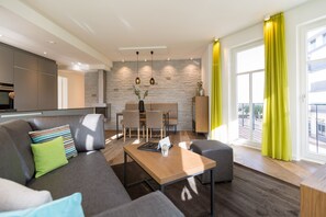 Una sala de estar moderna con un sofá, una mesa de centro y un comedor con sillas y una mesa.