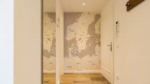 A hallway with a map of Europe on the wall, a wooden floor, and a door on the right. - Beachhouse Bansin, app. 14 (Heringsdorf)