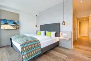 Quarto moderno com uma cama, mesa de cabeceira, quadro e corredor.