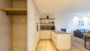 Een moderne keuken met houten vloeren, een centraal eiland en inbouwmeubels.