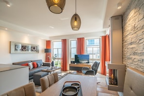 A modern living room with a sofa, dining table, and a fireplace. - Beachhouse Bansin, App. 21 (Heringsdorf)