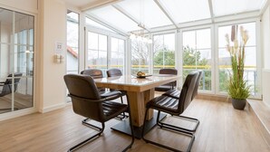 A modern conference room with a glass table, leather chairs, and a large window with a view of trees and buildings. - Haus am Schloonsee, app. B7 (Heringsdorf)