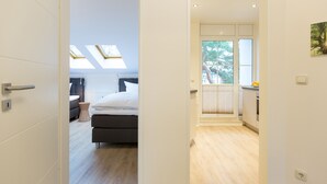 A modern hotel room with a skylight, a bed, a small table, and a view of the outdoors. - Haus am Schloonsee, app. B7 (Heringsdorf)