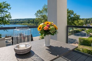 Un balcon avec une table, un vase de fleurs et un chandelier.