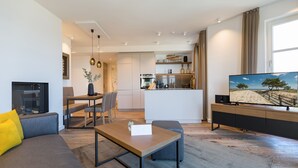 Una sala de estar moderna con un sofá, una mesa de centro y un televisor sobre un mueble.