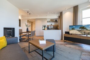 A modern living room with a sofa, coffee table, and a TV on a stand.