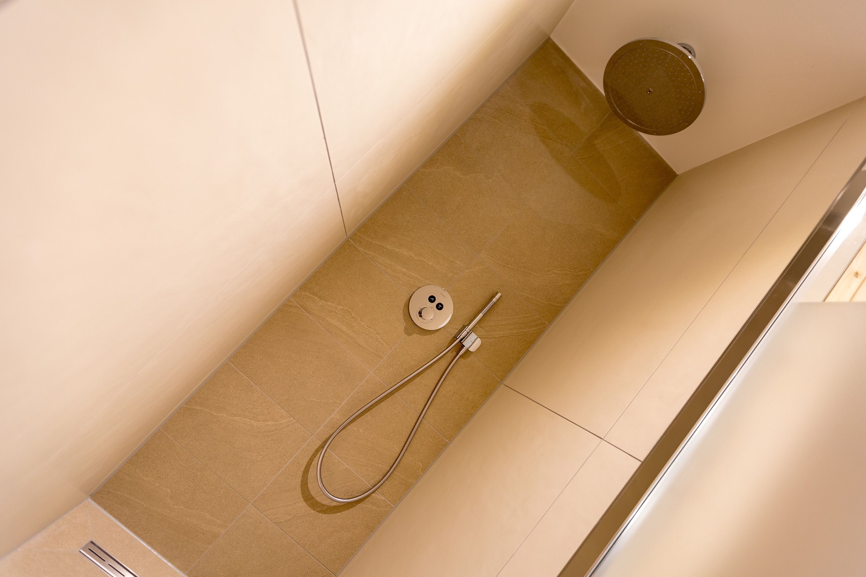 A modern bathroom with a shower, a toilet, and a sink.